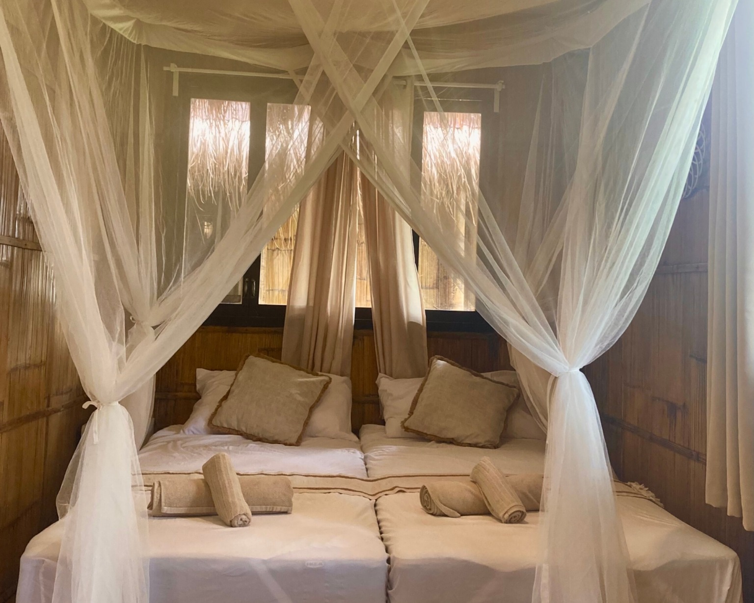 Image showcasing a comfortable bed with a mosquito net in a Family Bungalow at BlissBamboo Homestay on Siargao.